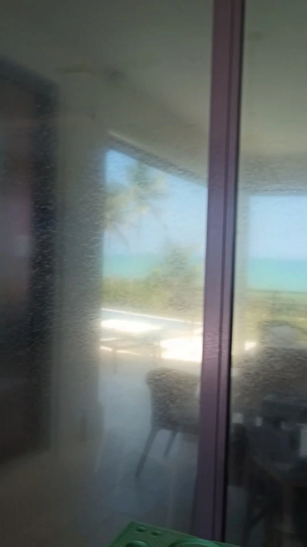 Ocean-facing sliding door clouded with salt film and haze before cleaning, San Clemente, CA